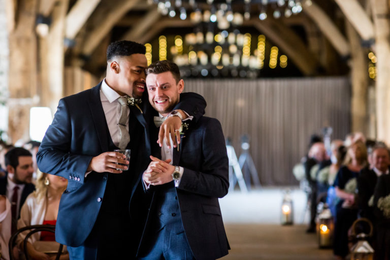Two men sharing a joyful moment and toasting at a formal event.