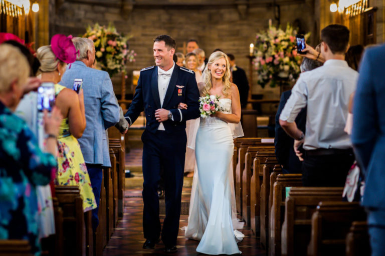 A bride and groom walking down the aisle during a wedding ceremony in a church.