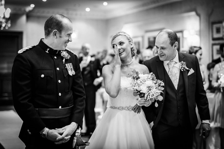 Black and white photo of a bride and groom walking down the aisle during their wedding ceremony.
