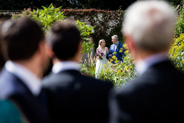 A wedding ceremony in a garden with a bride and groom.