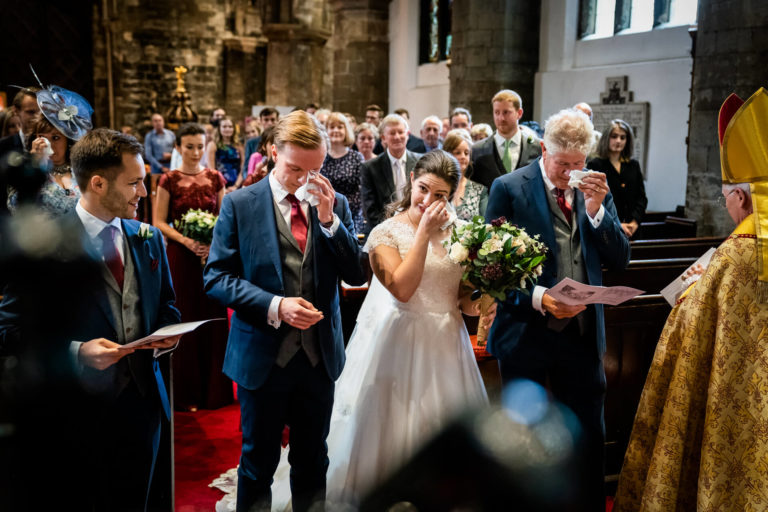 bride and groom and father of the bride shedding a tear during the ceremony
