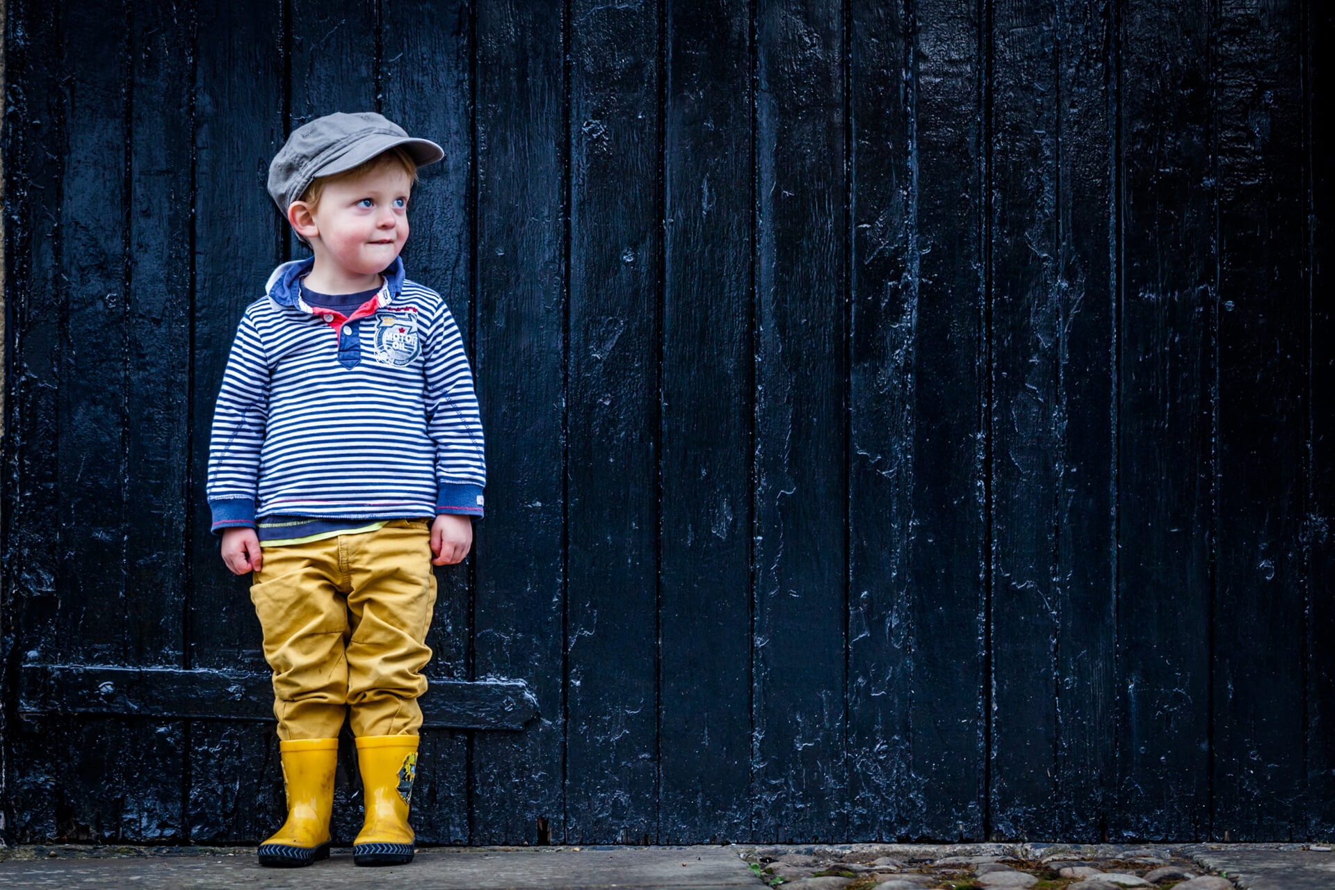 small boy stood in front of a garage door