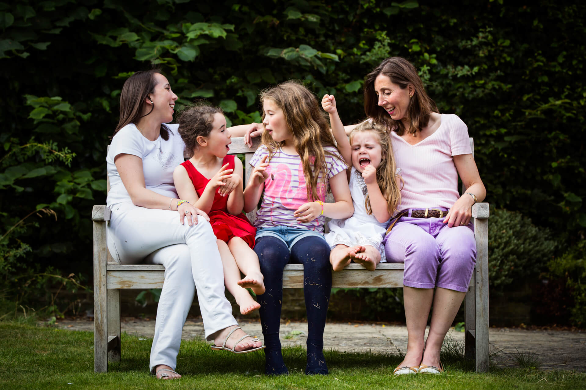 A group of girls sitting on a bench.