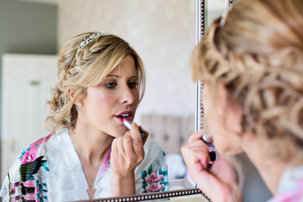 Hornington Manor Wedding Photography - bride applying lipstick
