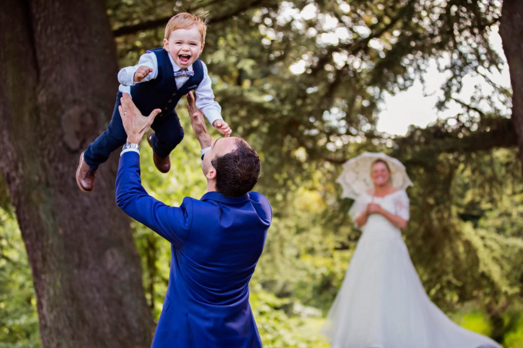 Askham Hall wedding photography - groom throwing pageboy into the air