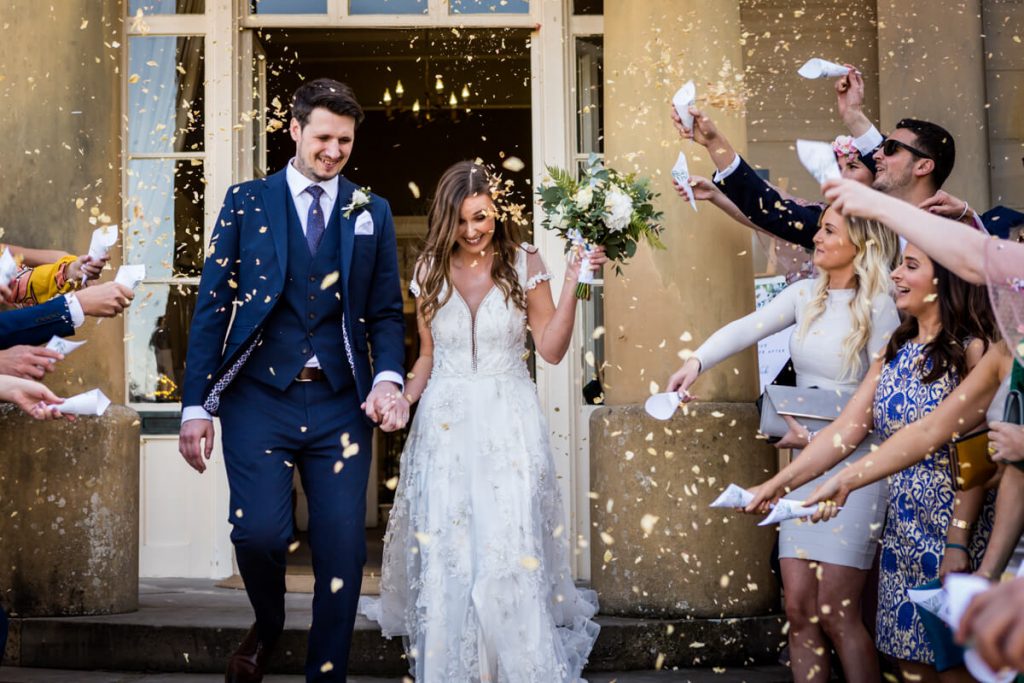 Guests throwing confetti over the bride and groom