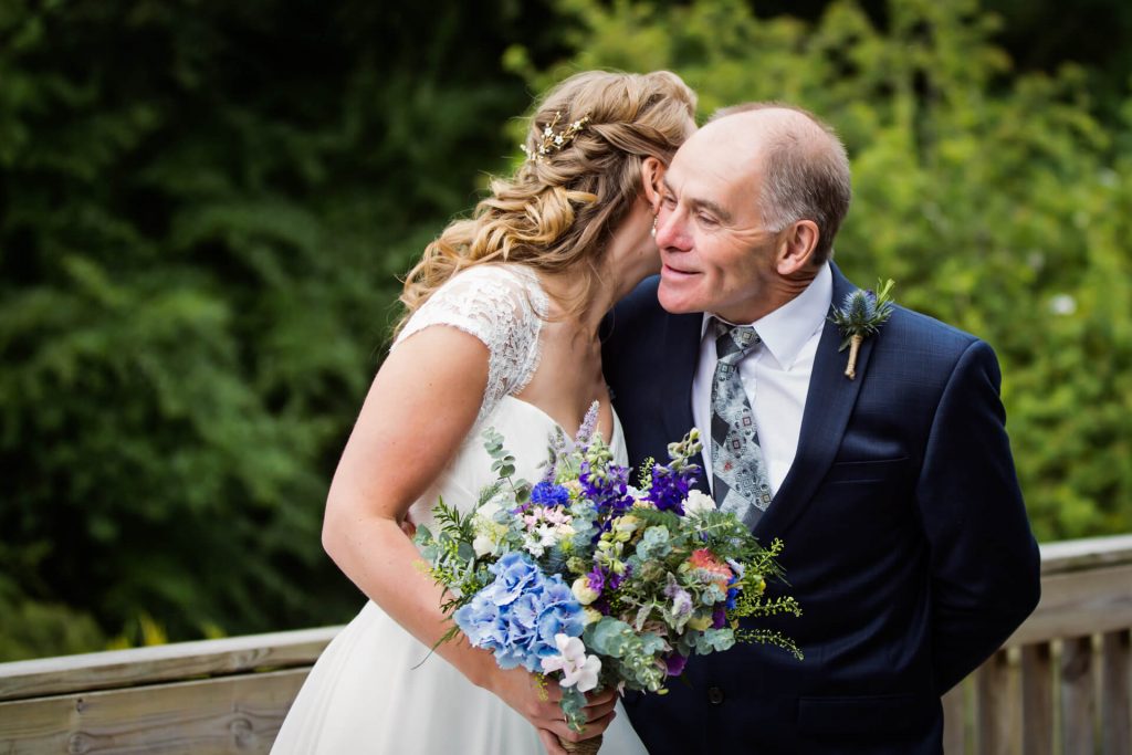 bride whispering in her Dad's ear