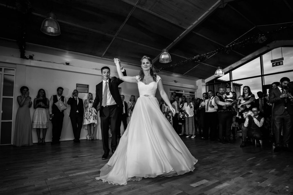 groom swings the bride around the dance floor