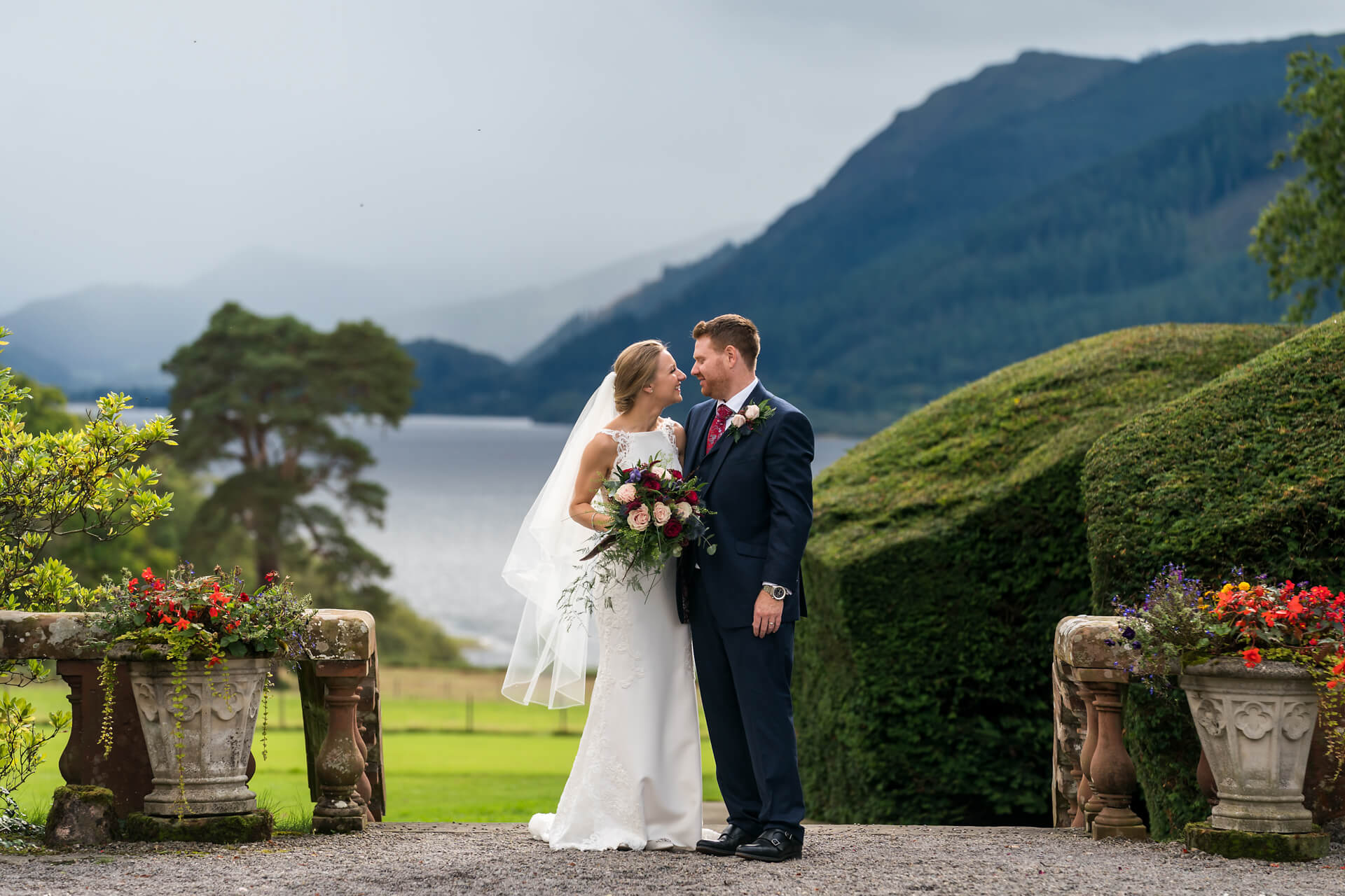 wedding couple hugging in front of the lake view at Armathwaite hall