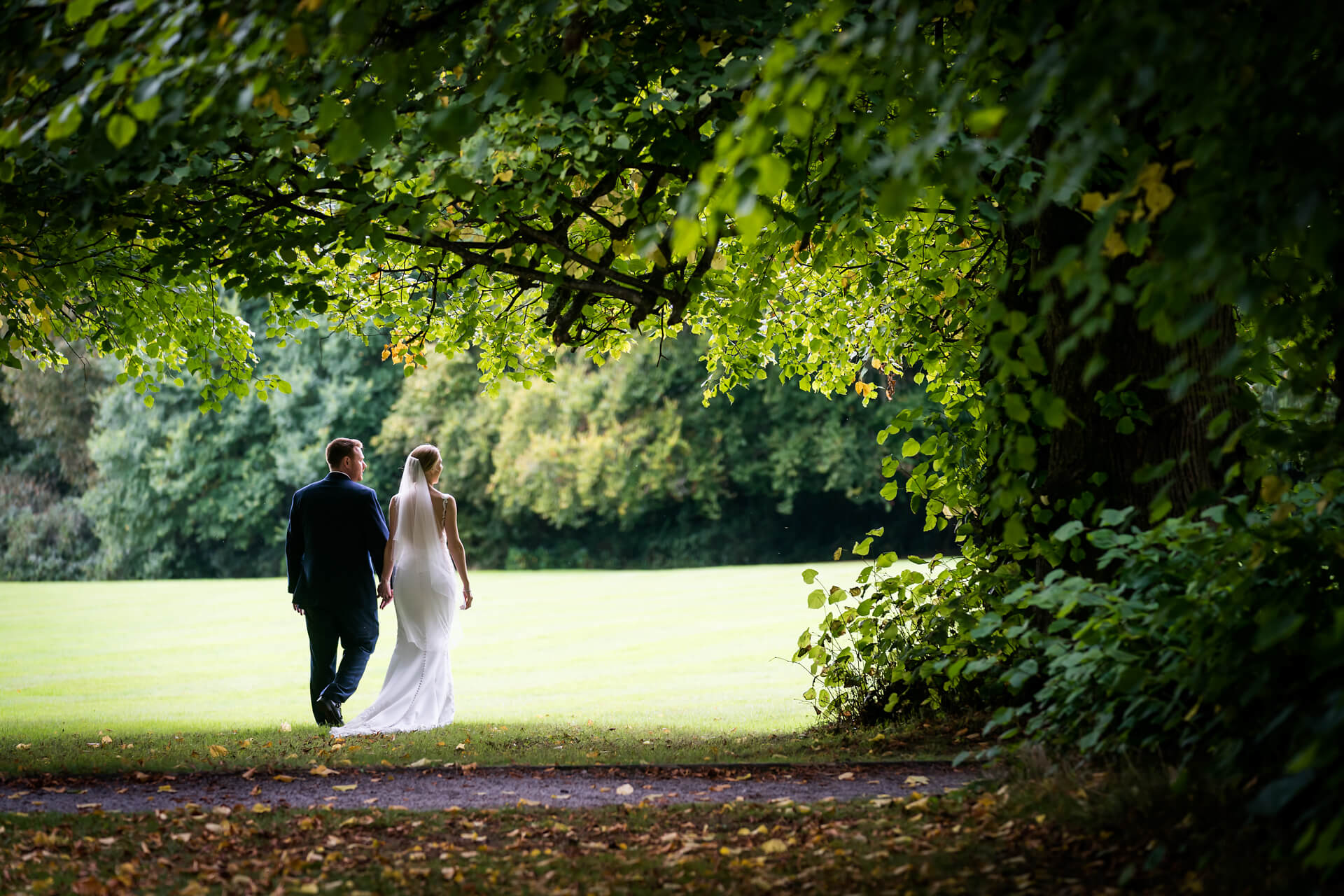 bride and groom walk in the grounds of Armathwaite Hall