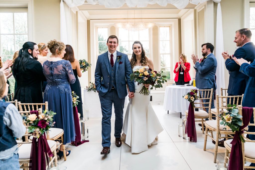 bride and groom walk down the aisle at Saltmarshe Hall