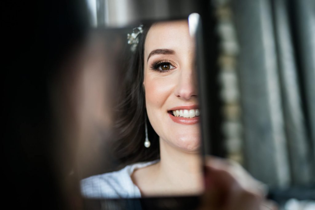 bride smiling in a mirror