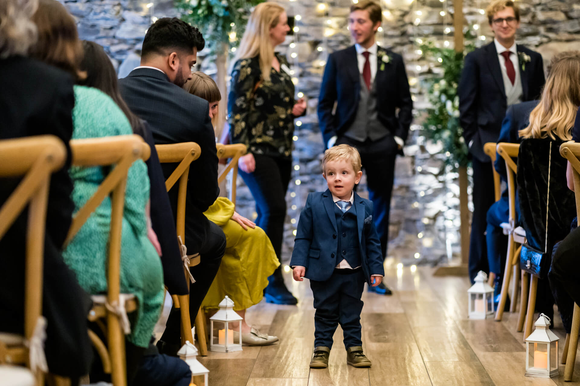 little boy standing into middle of the wedding aisle
