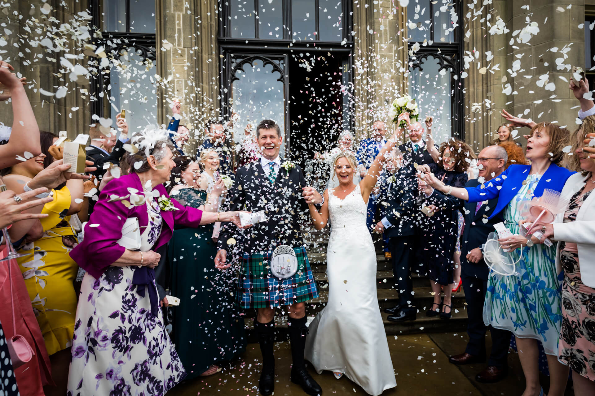 guests showering the wedding couple with confetti at Allerton Castle