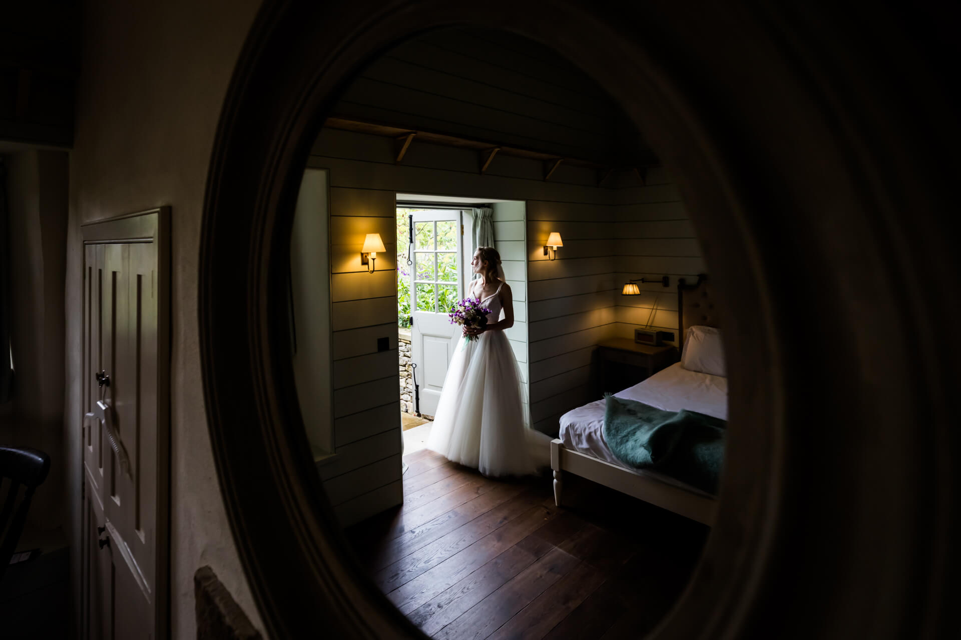 reflection of the bride in a mirror as she looks out of the doorway