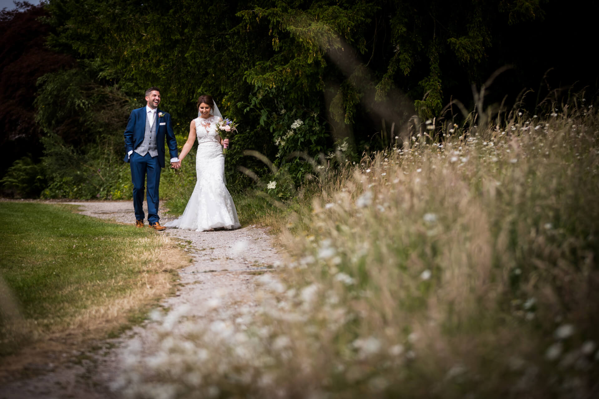 wedding couple walking along a path at Ripley Castle