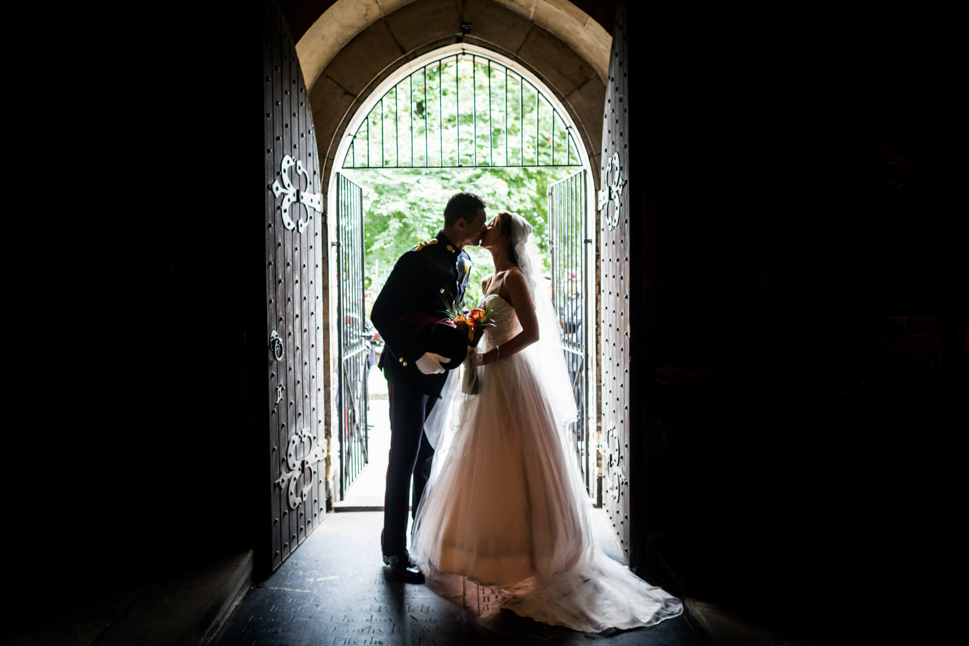 wedding couple kissing in the church doorway