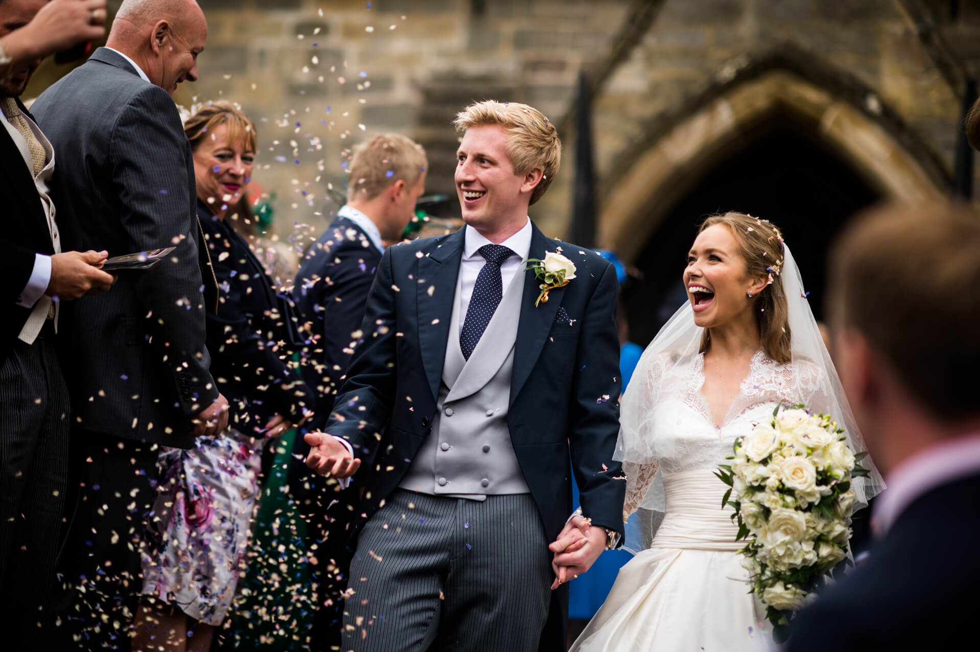 bride and groom are showered with confetti outside the church in Harrogate