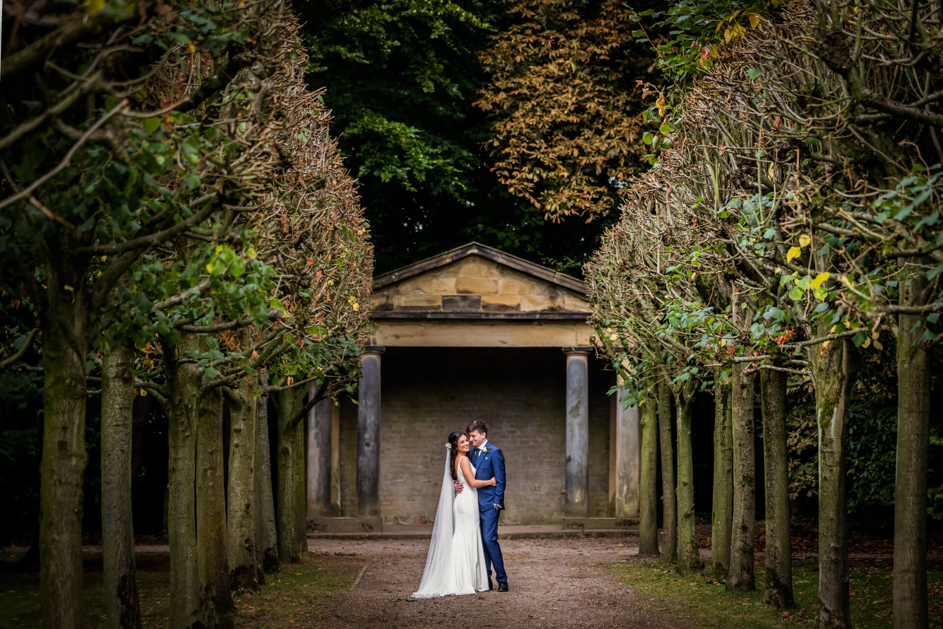 bride and groom cuddle in the grounds of Lotherton Hall