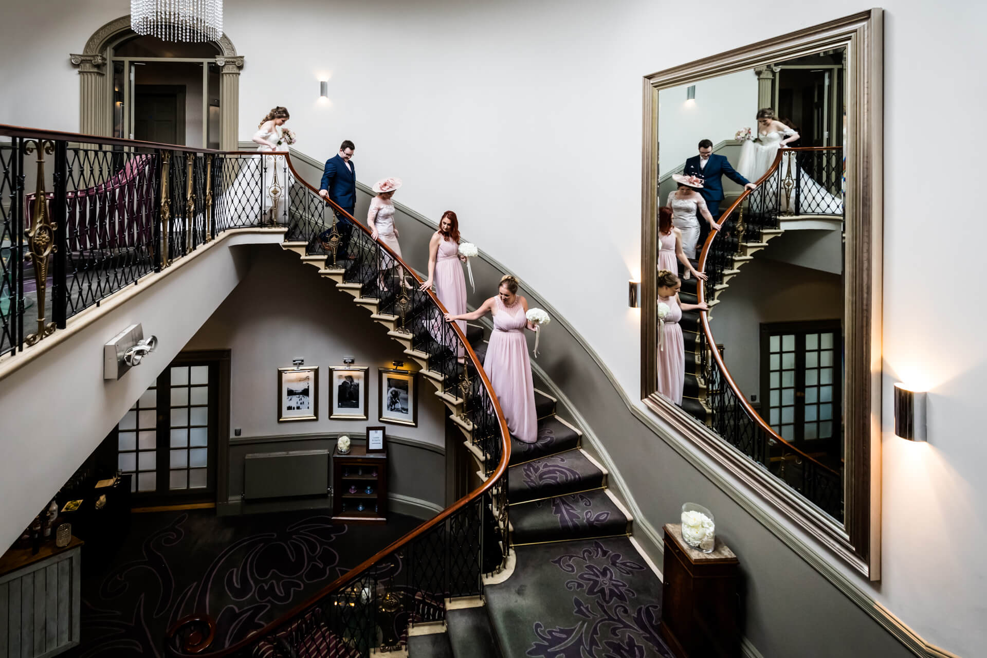 bridal party walk down the stairs of The Mansion in Leeds