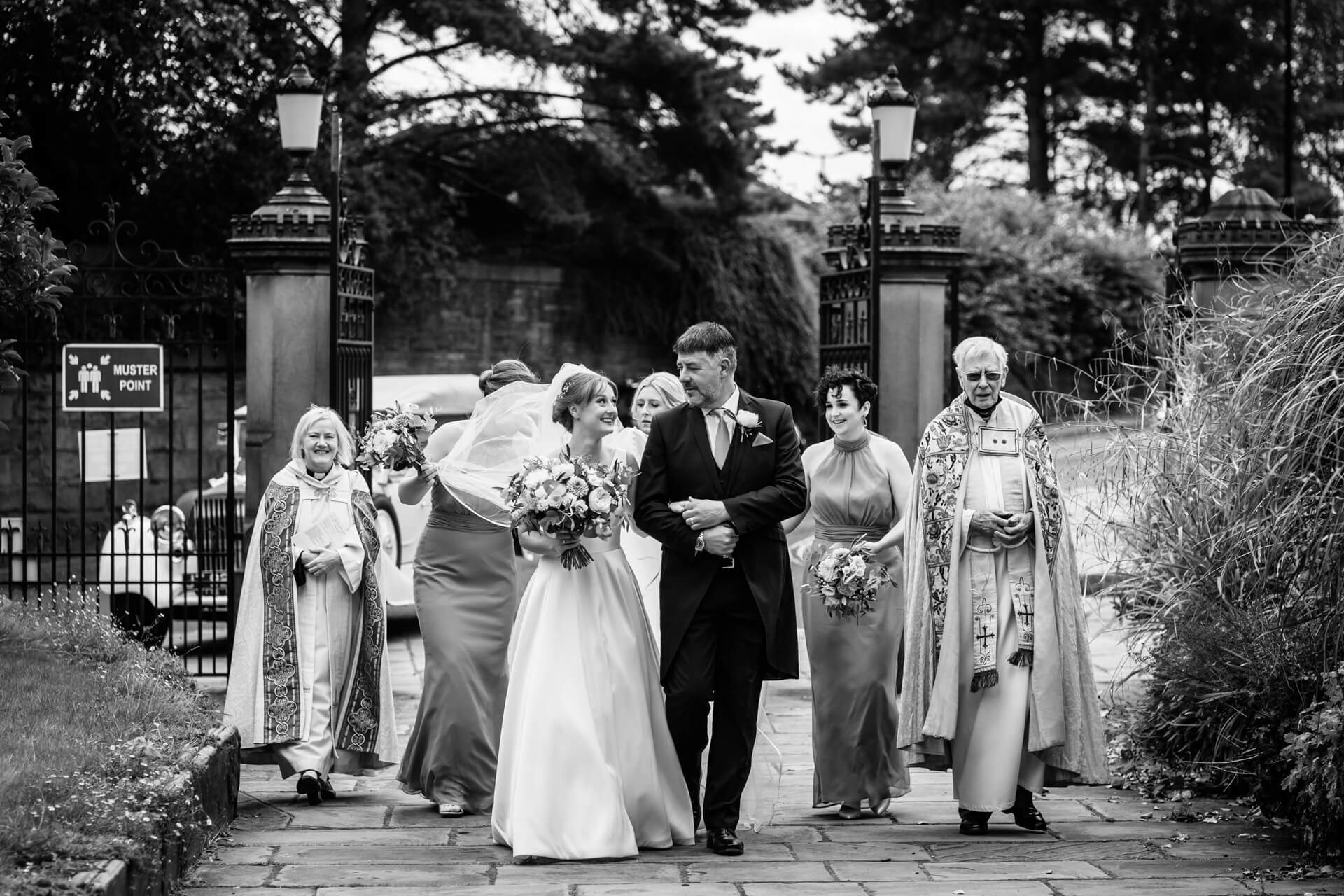 bride and the bridal party arrive at the gates of the cathedral