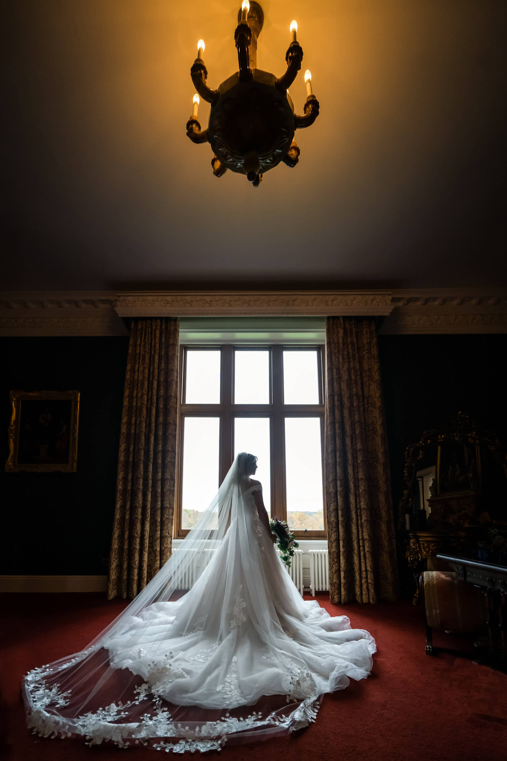 bride standing in front of a window at Allerton castle