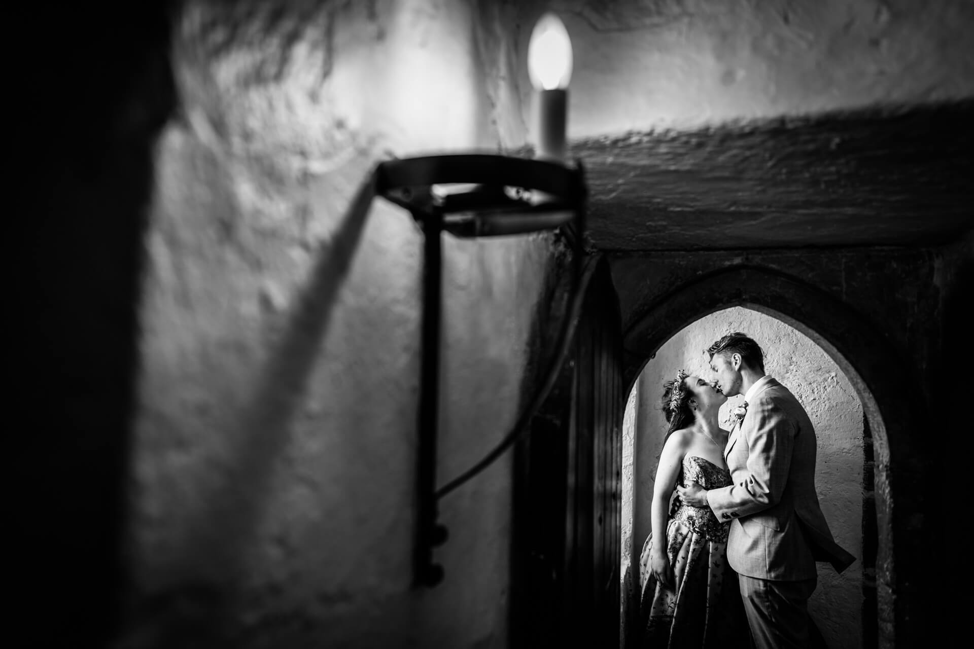 bride and groom kissing under an archway inside Bolton castle