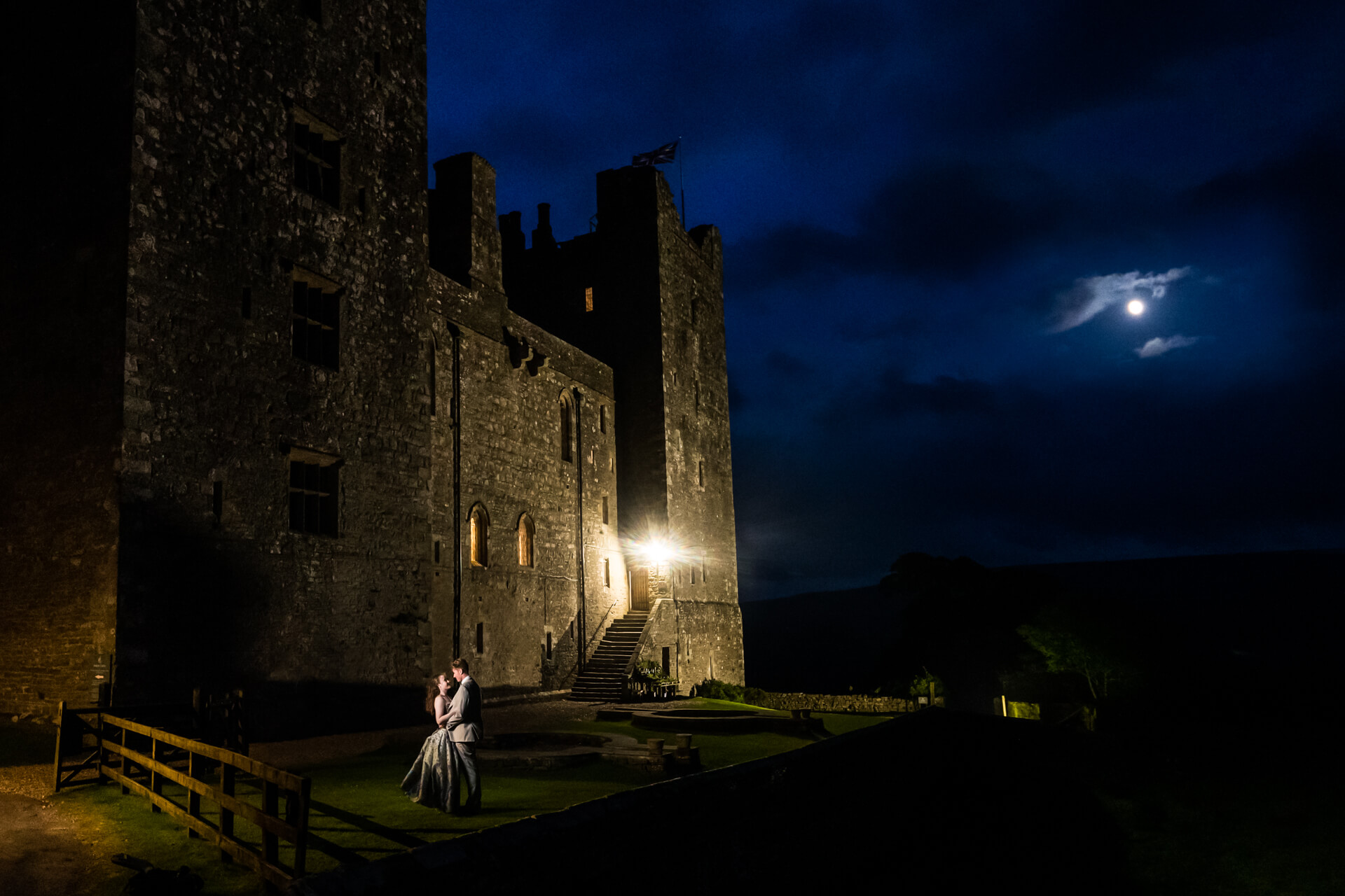 nighttime portrait of the wedding couple outside Bolton Castle