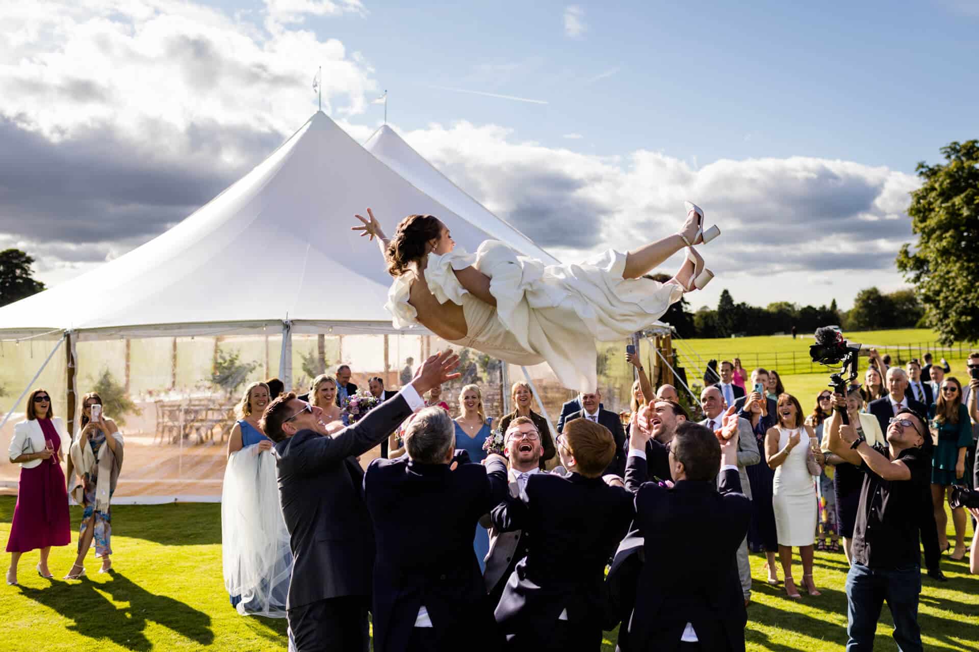 bride being thrown in the air by the groomsmen