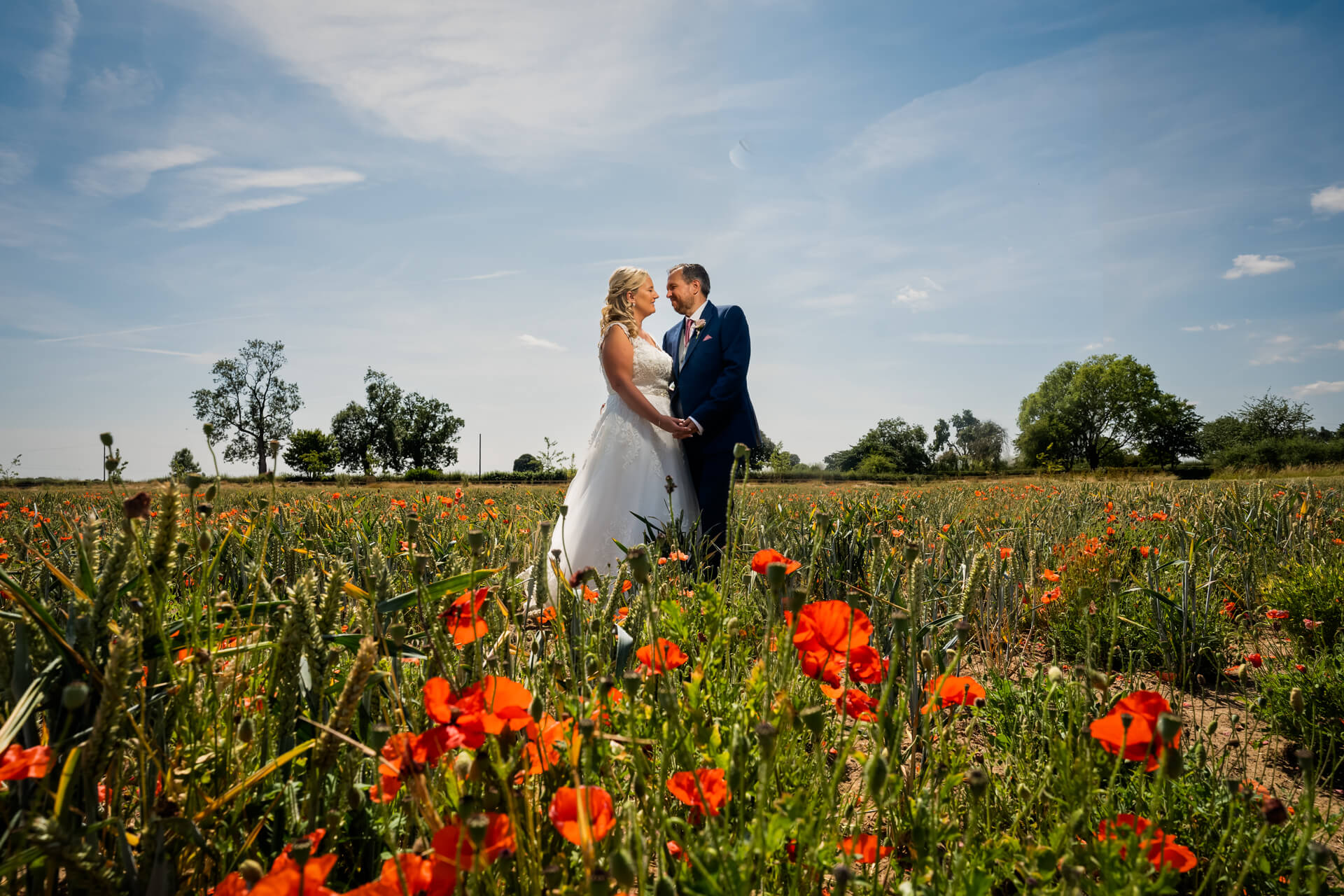 wedding couple in a poppy field at Thirsk Lodge Barns
