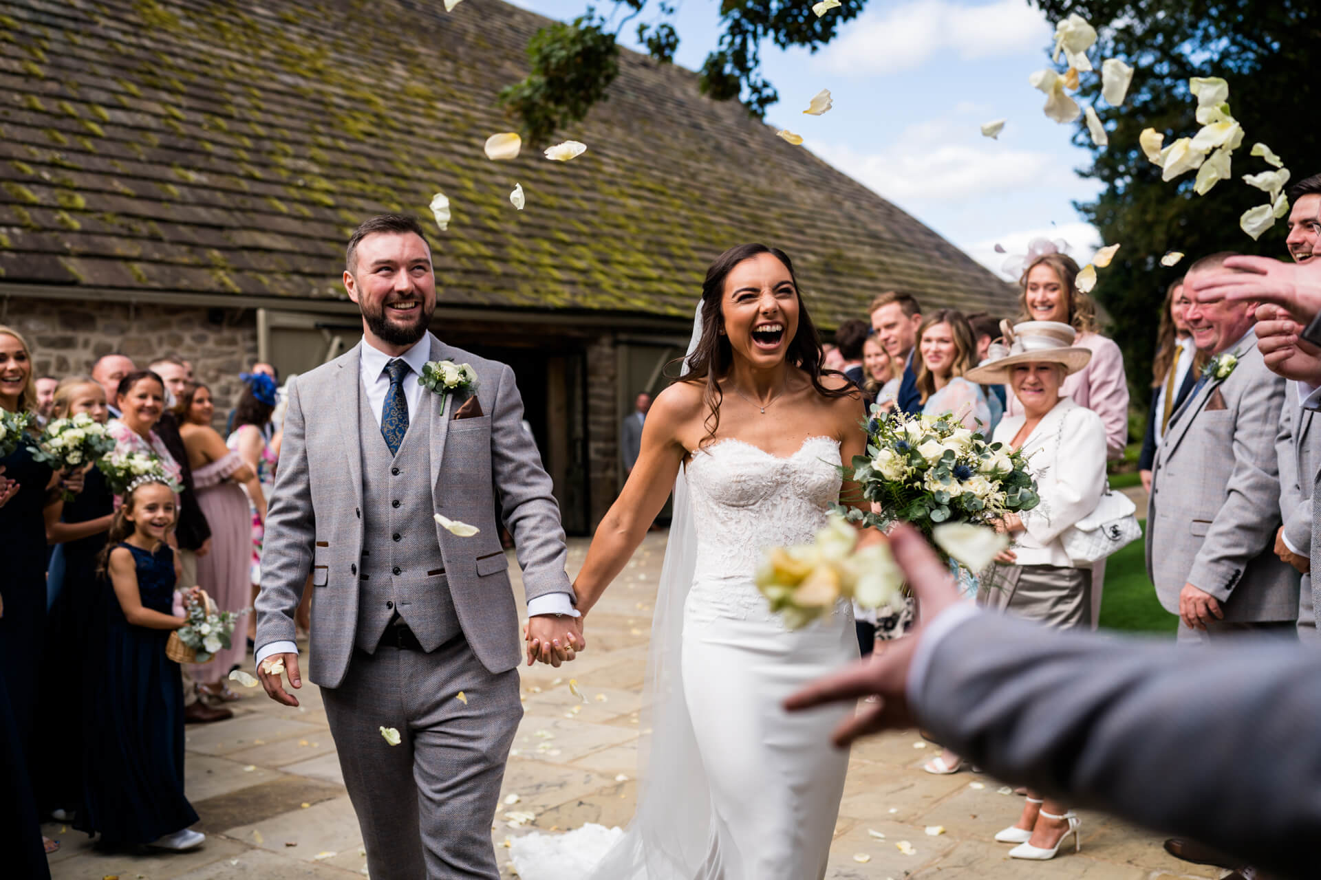 bride and groom being showered with confetti at Tithe Barn