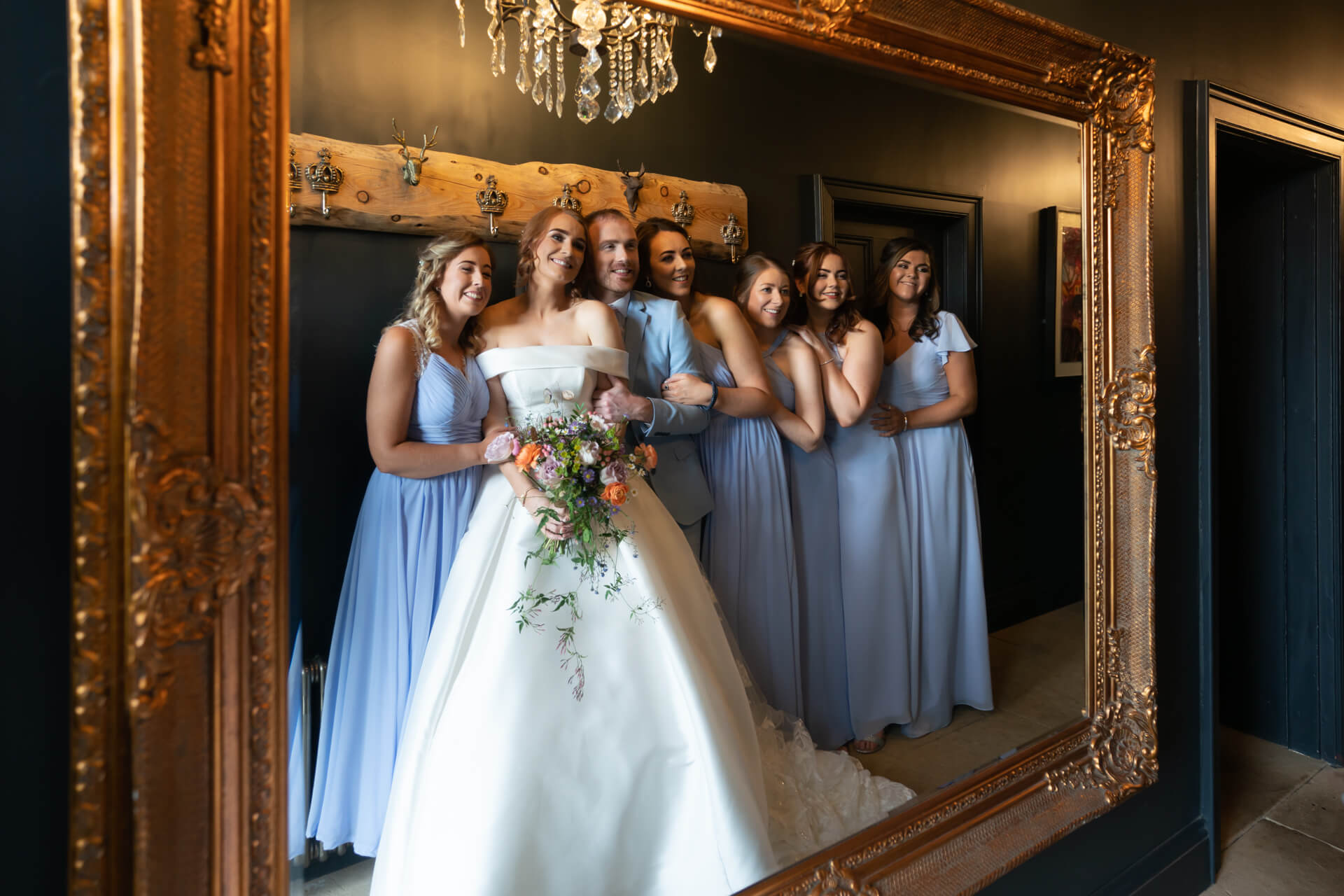bride and her bride tribe reflected in a large mirror at Wharfedale Grange