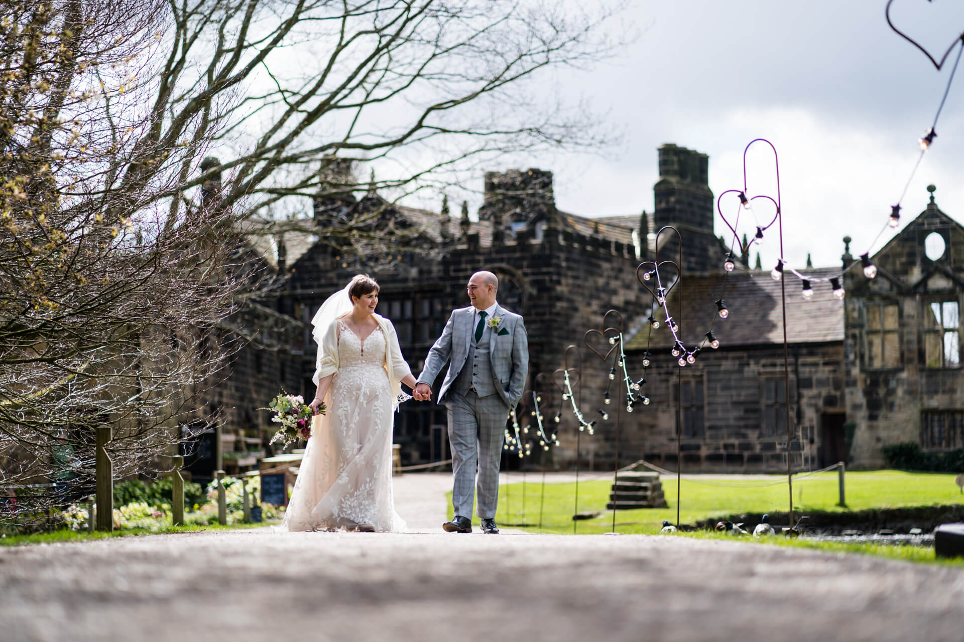 wedding couple walk down a path at East Riddlesden Hall