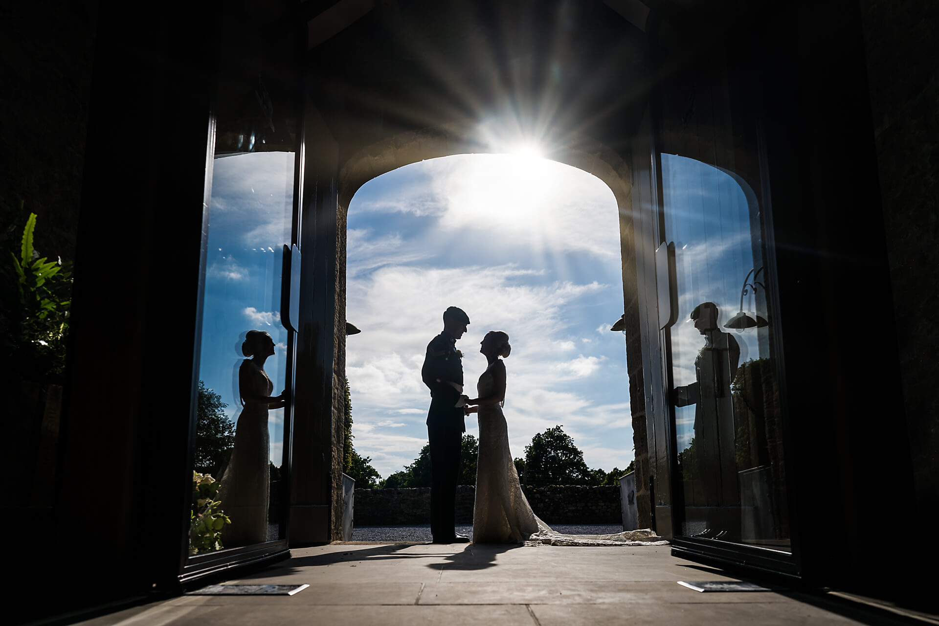 bride and groom under the arched doorway at Tithe Barn