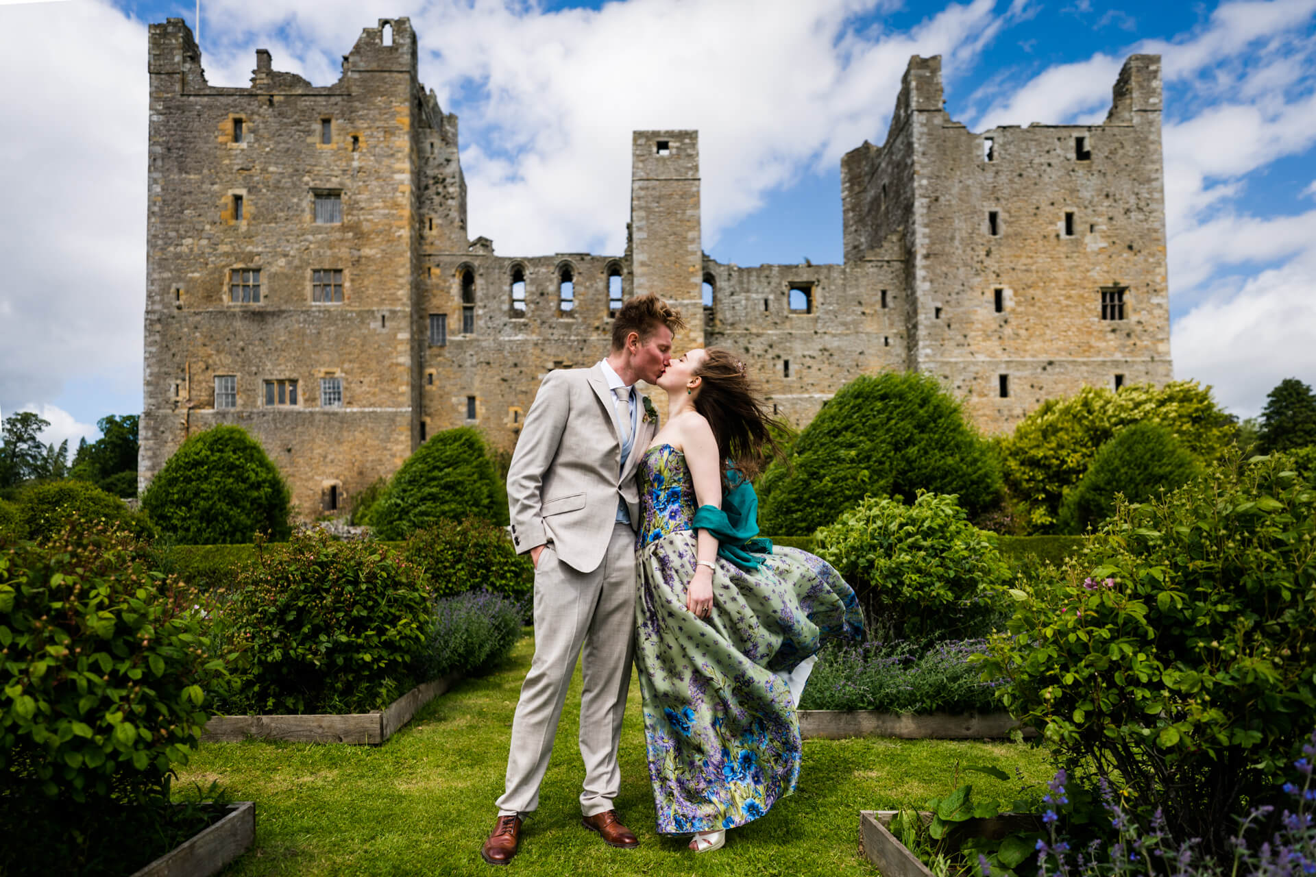 bride and groom kissing in front of bolton castle
