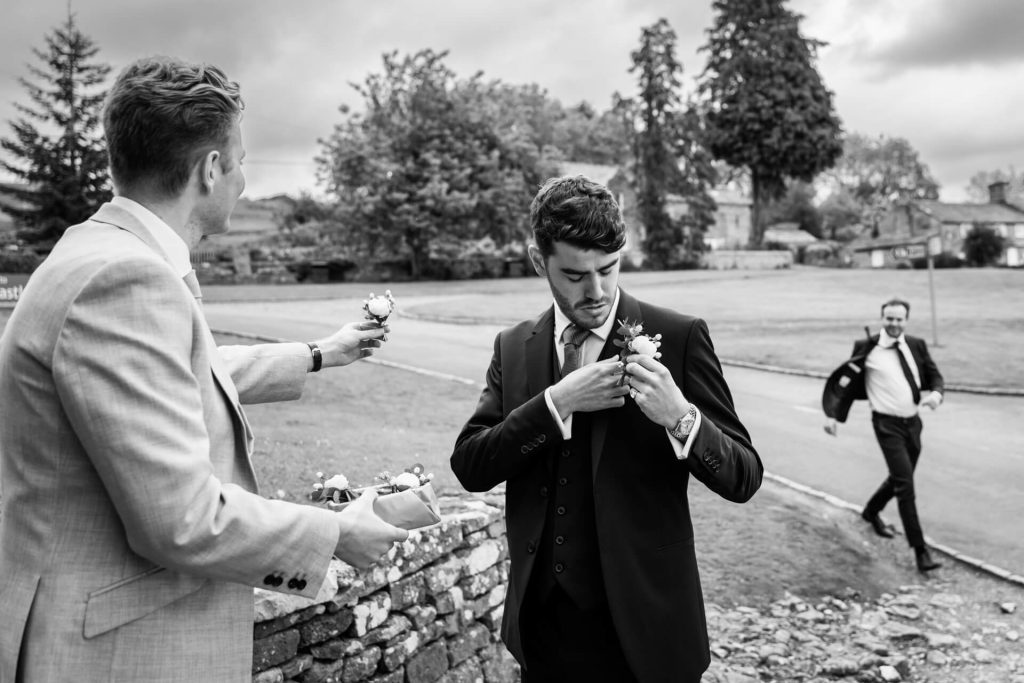 groomsmen attaching their buttonholes