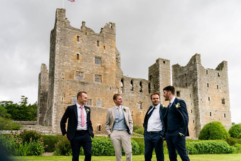 groom and groomsmen standing in front of Bolton Castle