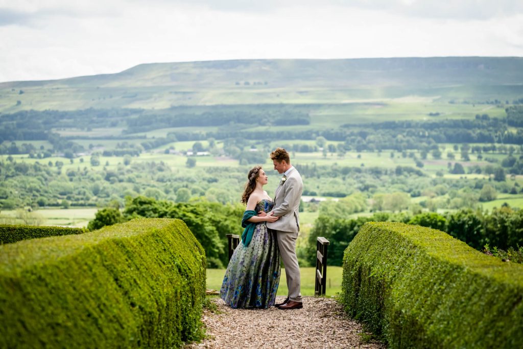 wedding couple standing in front of a view over Wensleydale