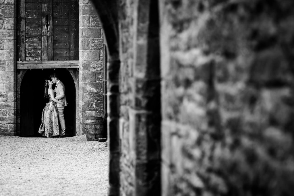 wedding couple kissing in a doorway at Bolton Castle