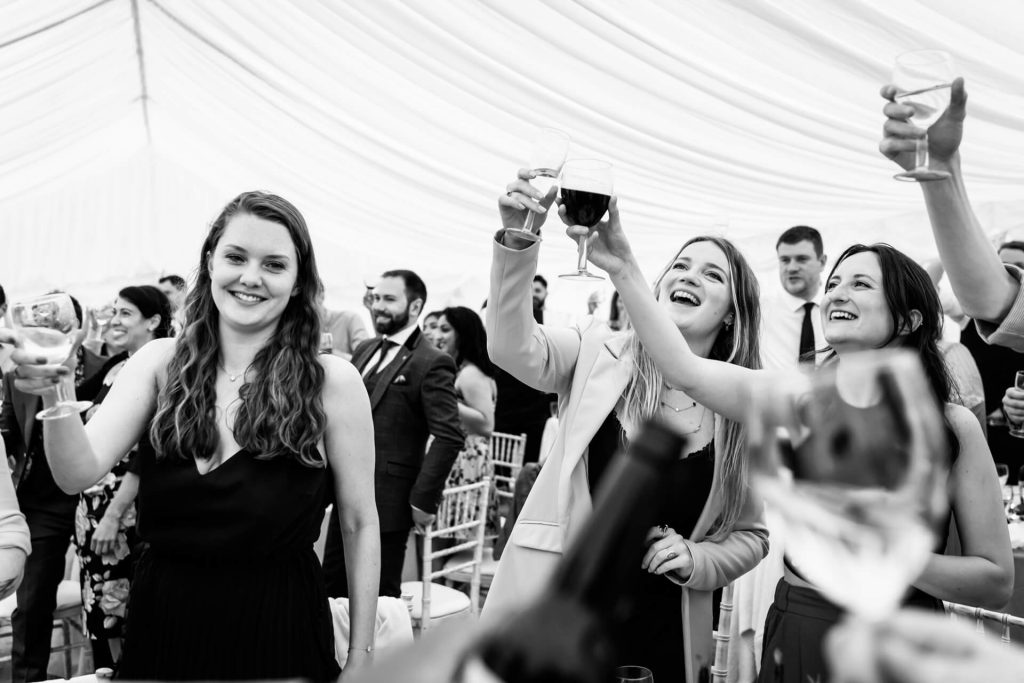 wedding guests cheering after the wedding speeches