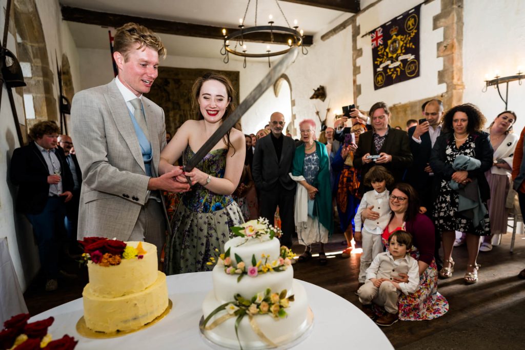 bride and groom cutting their wedding cake inside Bolton Castle