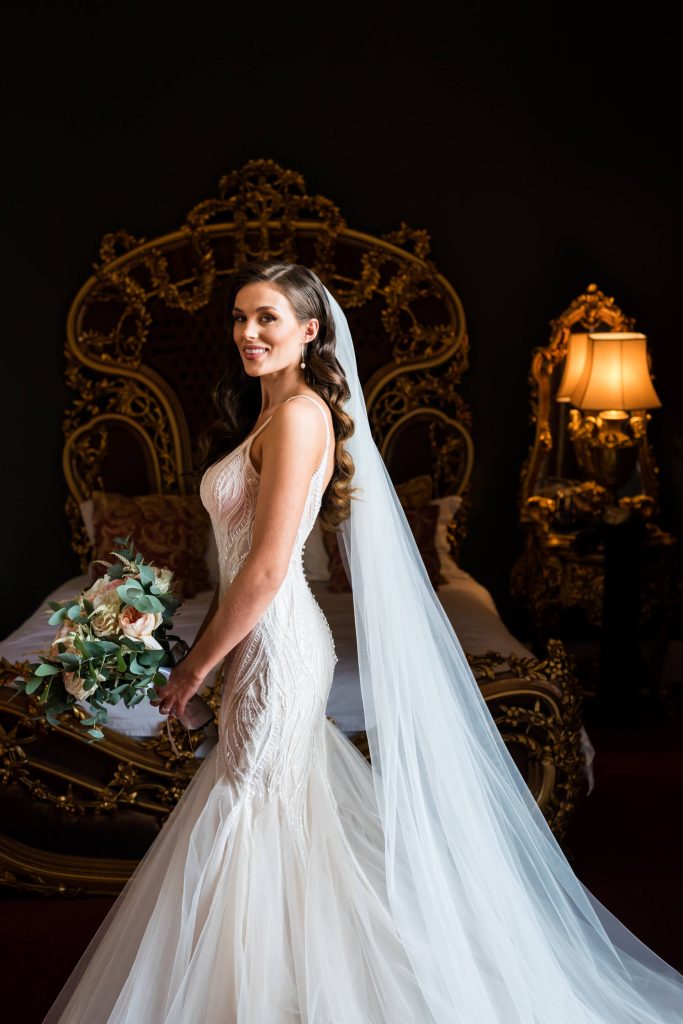 bride in front of the bed in the bridal suite at Allerton Castle