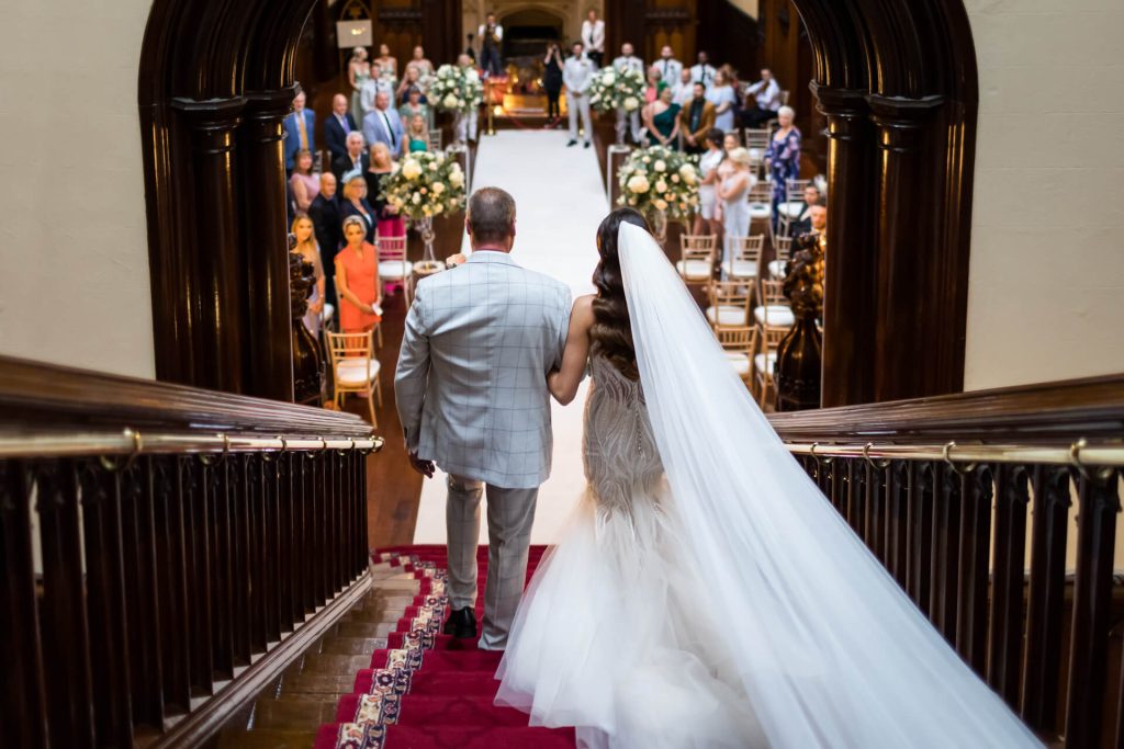 bride and her father walking down the staircase at Allerton Castle