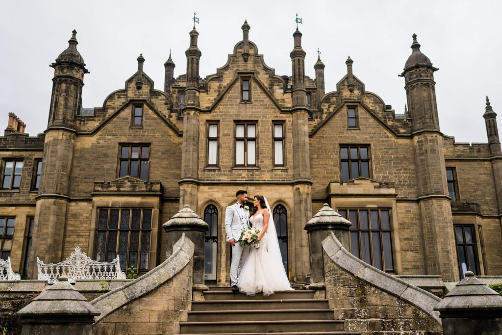 wedding couple on the steps in front of Allerton Castle
