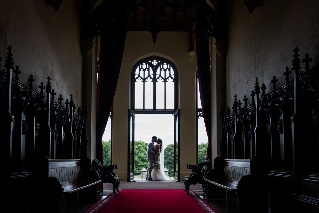 bride and groom kissing in a doorway at Allerton Castle