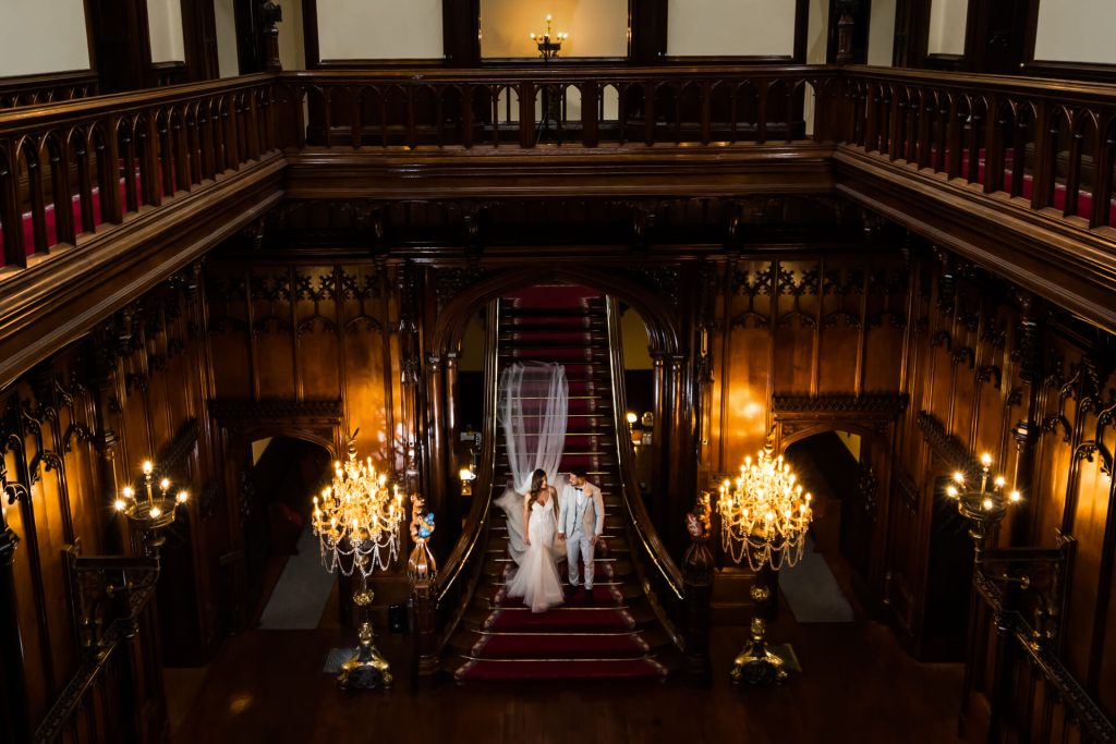 wedding couple on the grand staircase inside Allerton Castle
