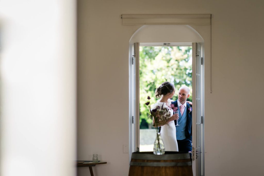view through two door to see the wedding couple hugging