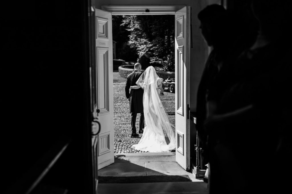 bride and groom leaving through the church doors