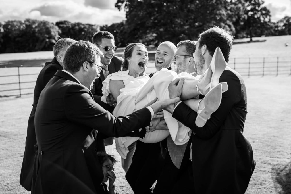 groomsmen holding the bride in the air