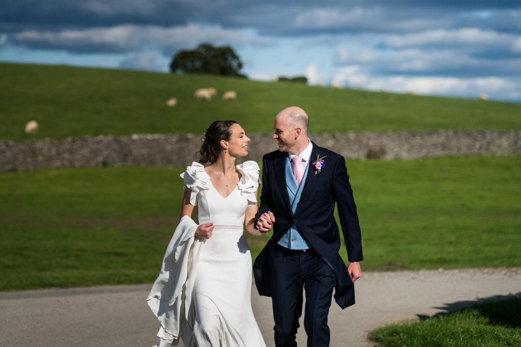 bride and groom walking together on the Broughton Hall Estate